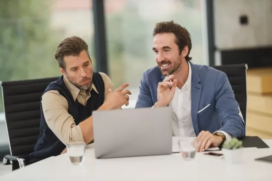 HR manager smiling while using a laptop